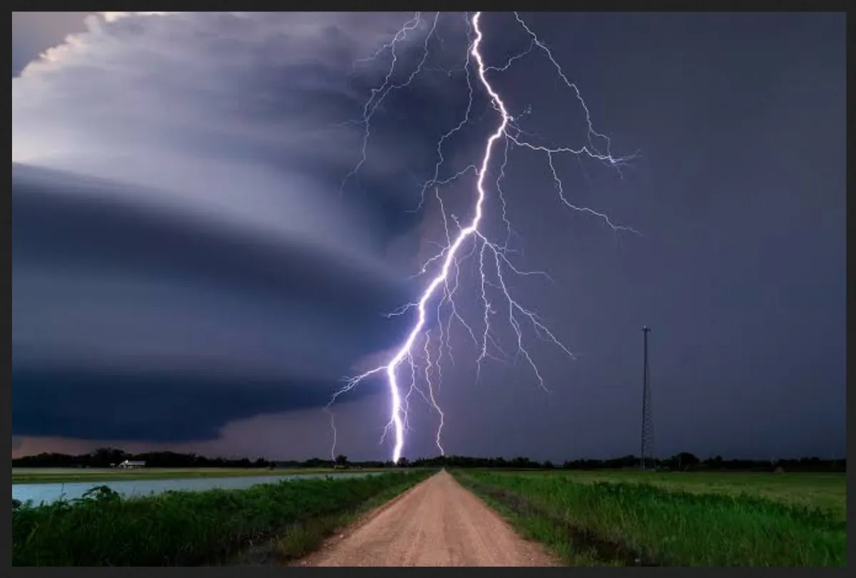 Lightning strikes near a rural road.