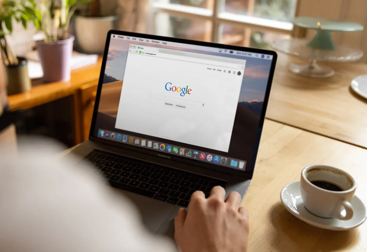 Person using laptop with Google search open.